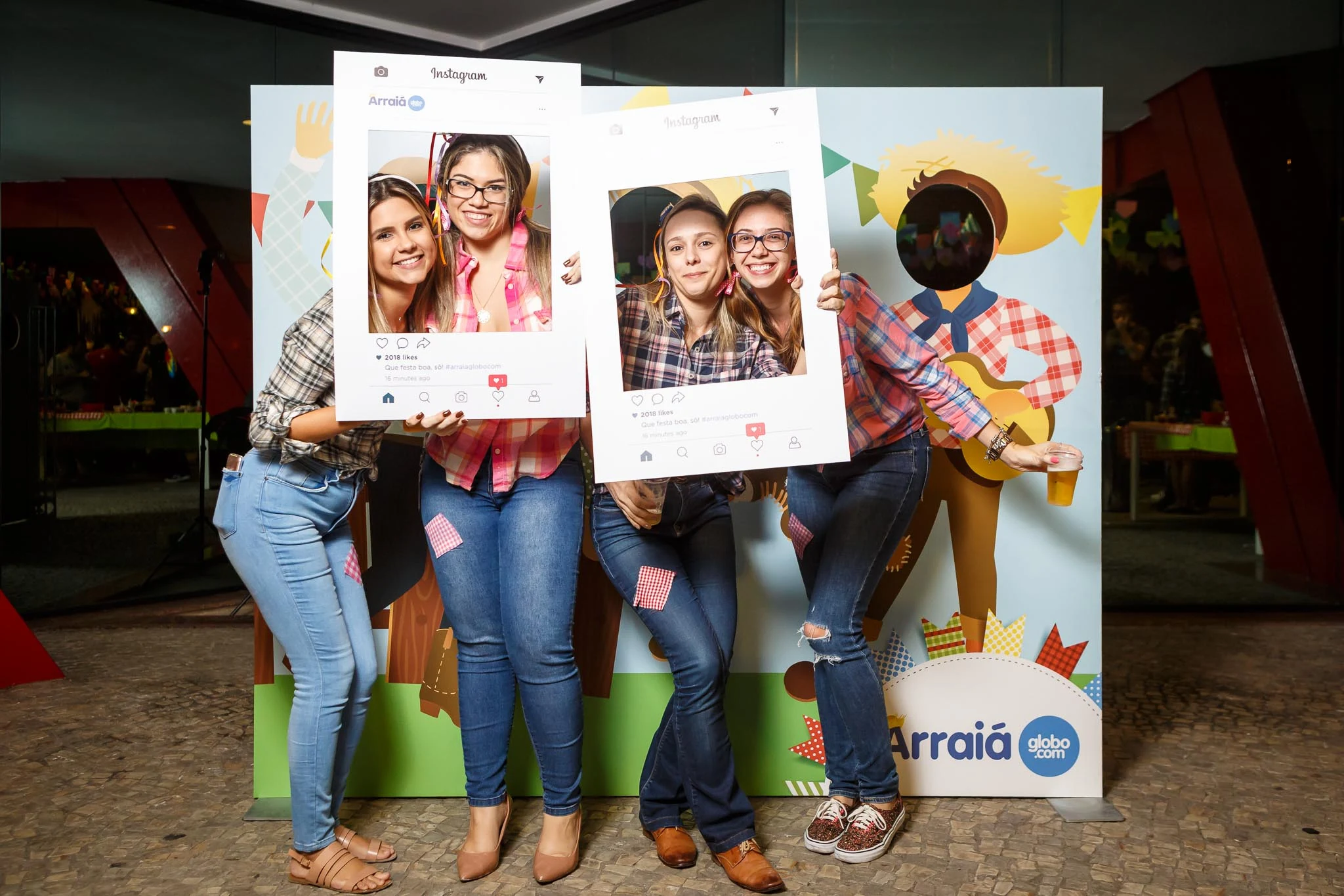 Guests posing with festive photo props at the Globo.com company party.