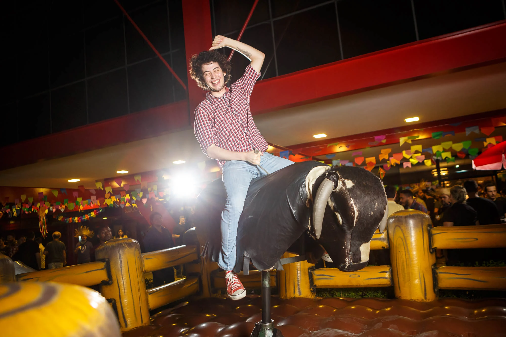 Guest riding a mechanical bull during the Globo.com company party.