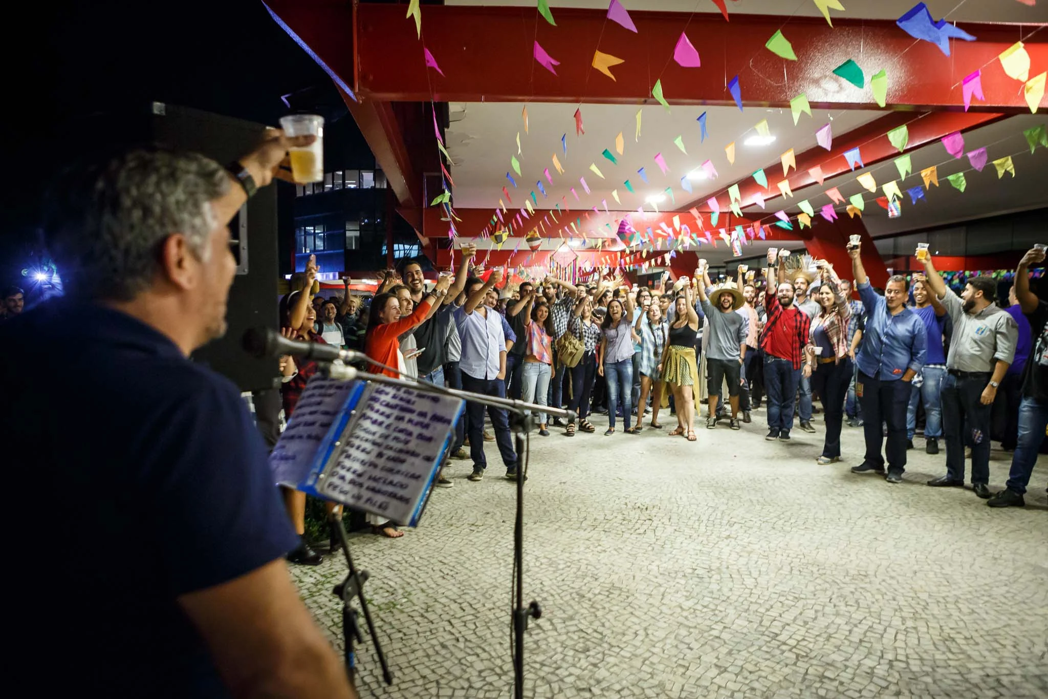 Live musicians performing for guests beneath festive bunting at the Globo.com company party.