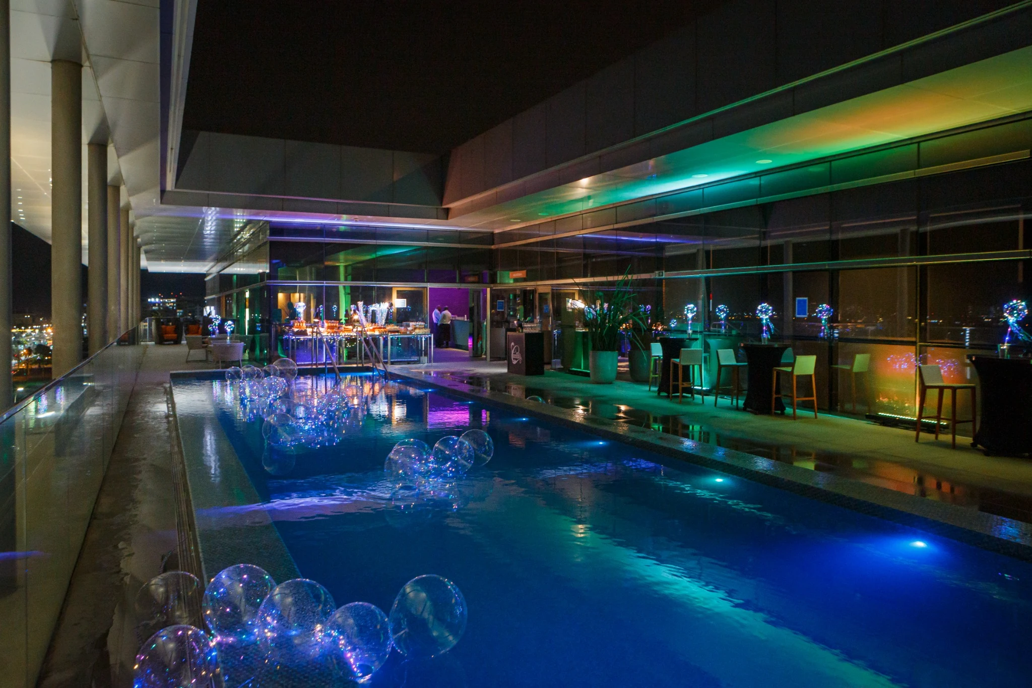 Hotel swimming pool and lounge illuminated at night.