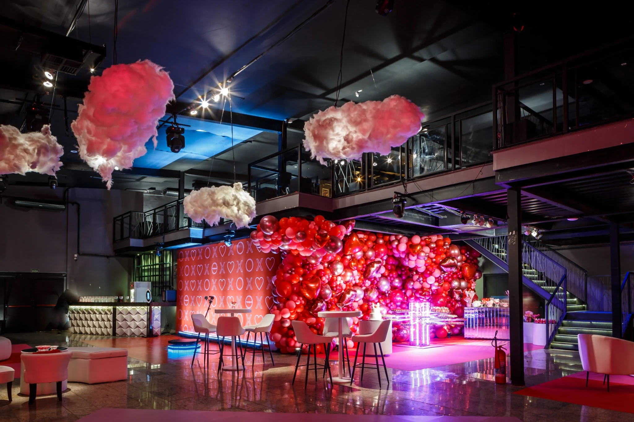 Event space with pink floral decorations and a red illuminated backdrop.