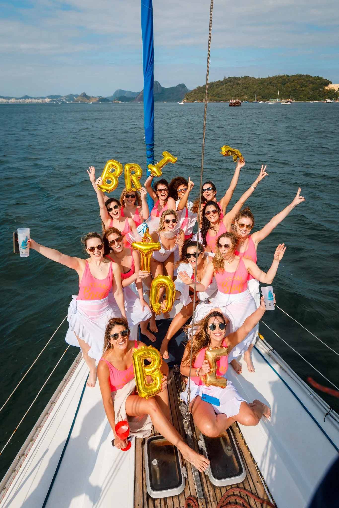 Bachelorette party posing together on the bow of a sailboat.