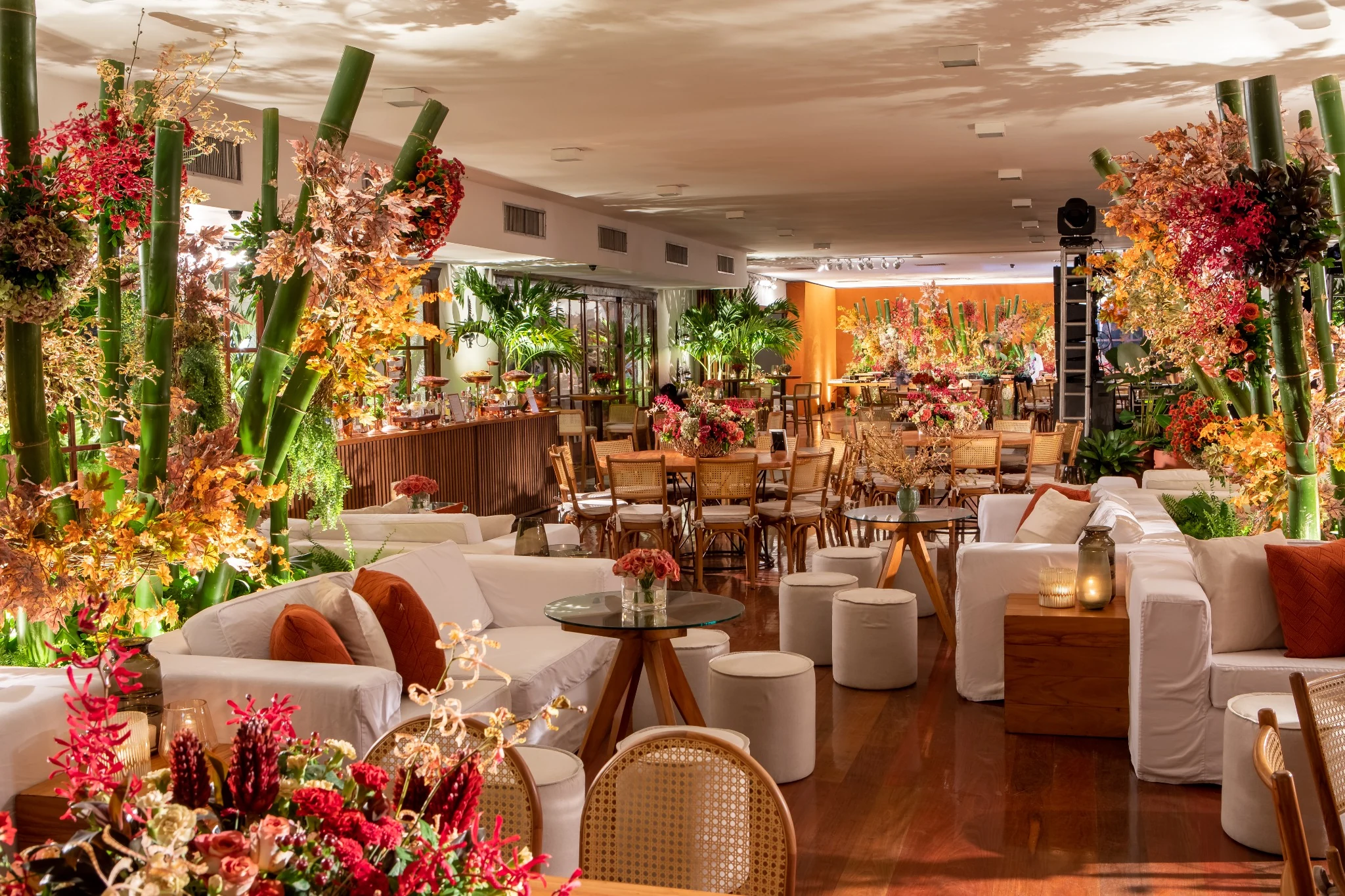Reception space decorated with flowers, seating and dining tables.