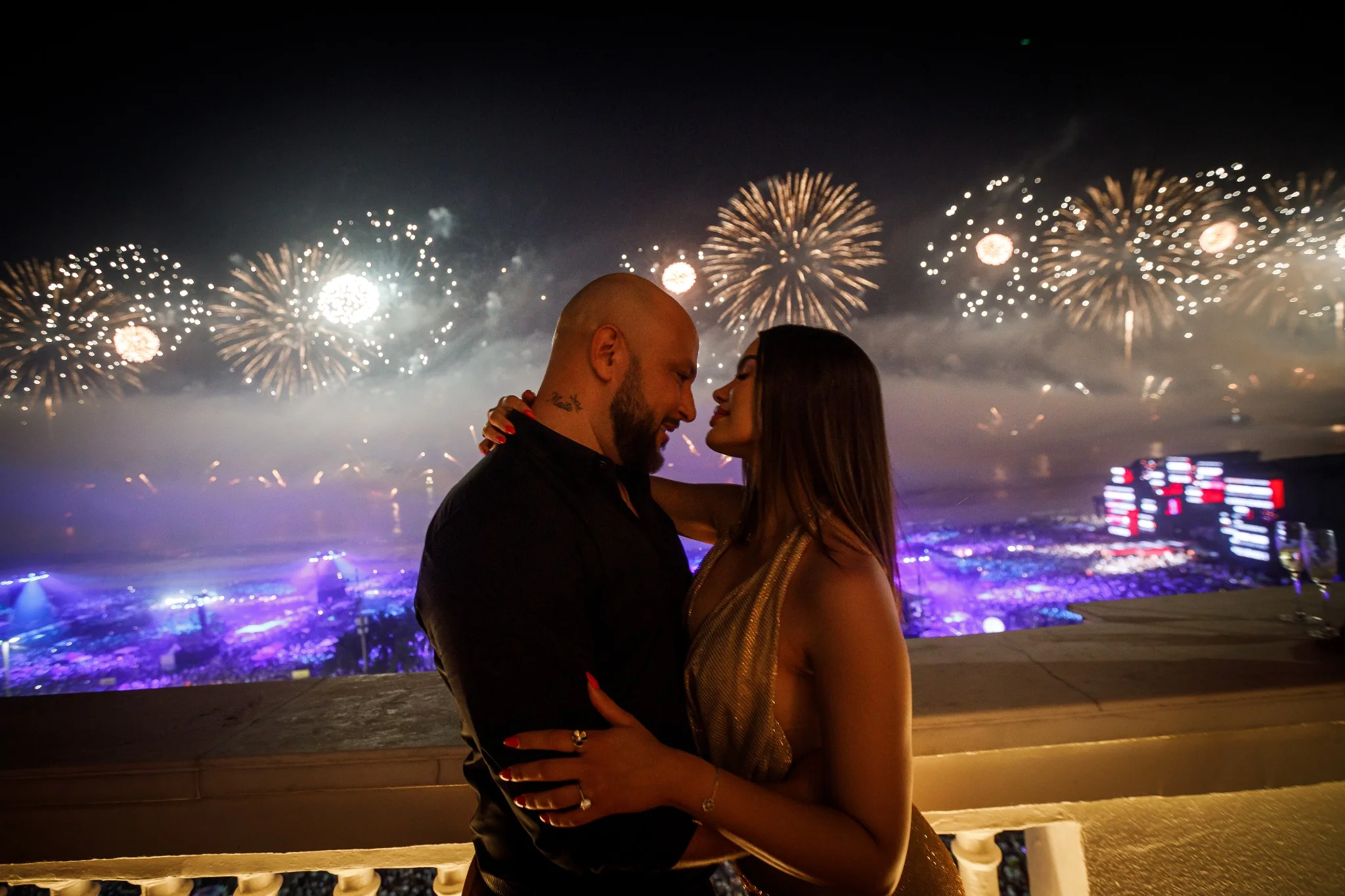 Engaged couple with Copacabana New Year fireworks in the background.