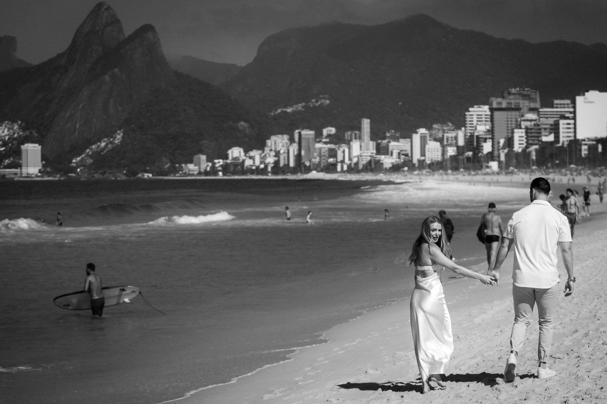 Couple walking along the beach at Arpoador, Rio de Janeiro, in black and white.