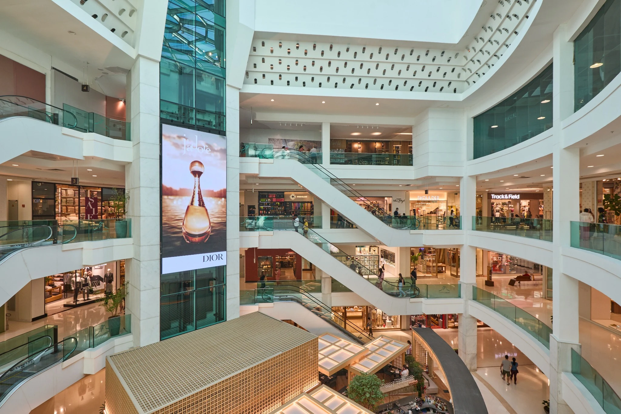 Interior of a shopping centre with multiple floors and escalators.